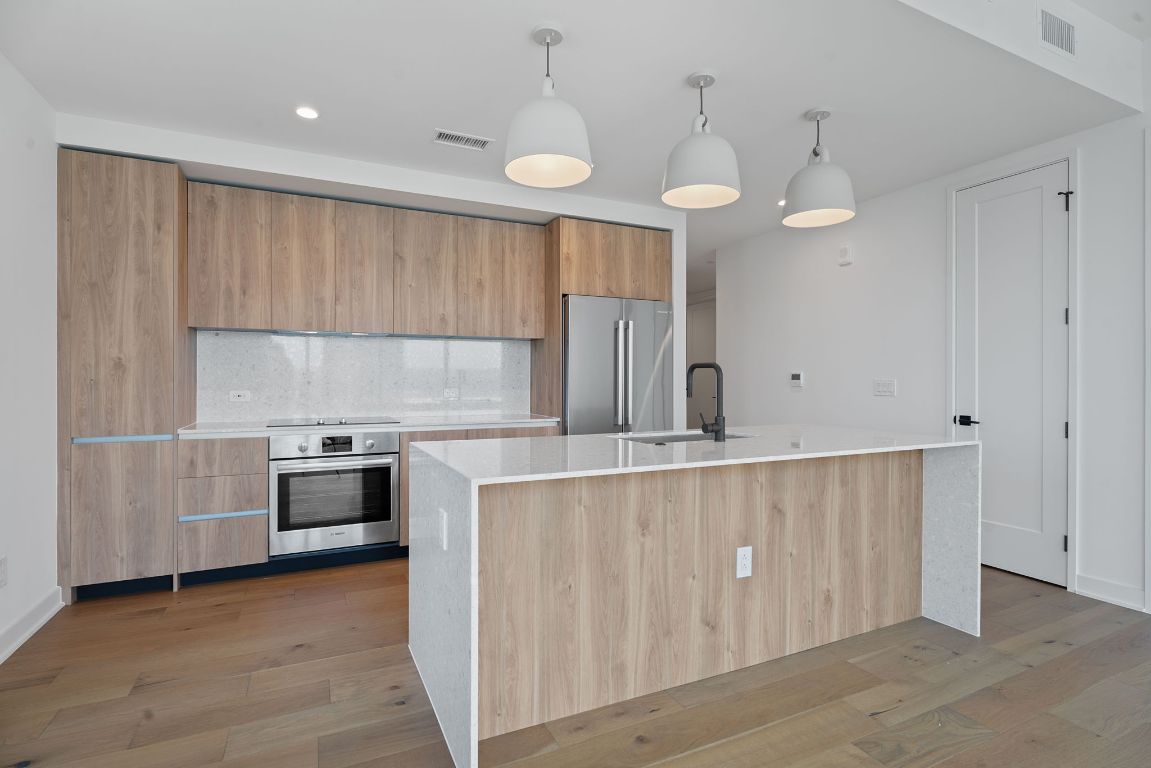 84 East Avenue, Unit 3401 Austin, TX 78701 - Photo 10 of 40 a kitchen with stainless steel appliances a stove a sink a center island and cabinets