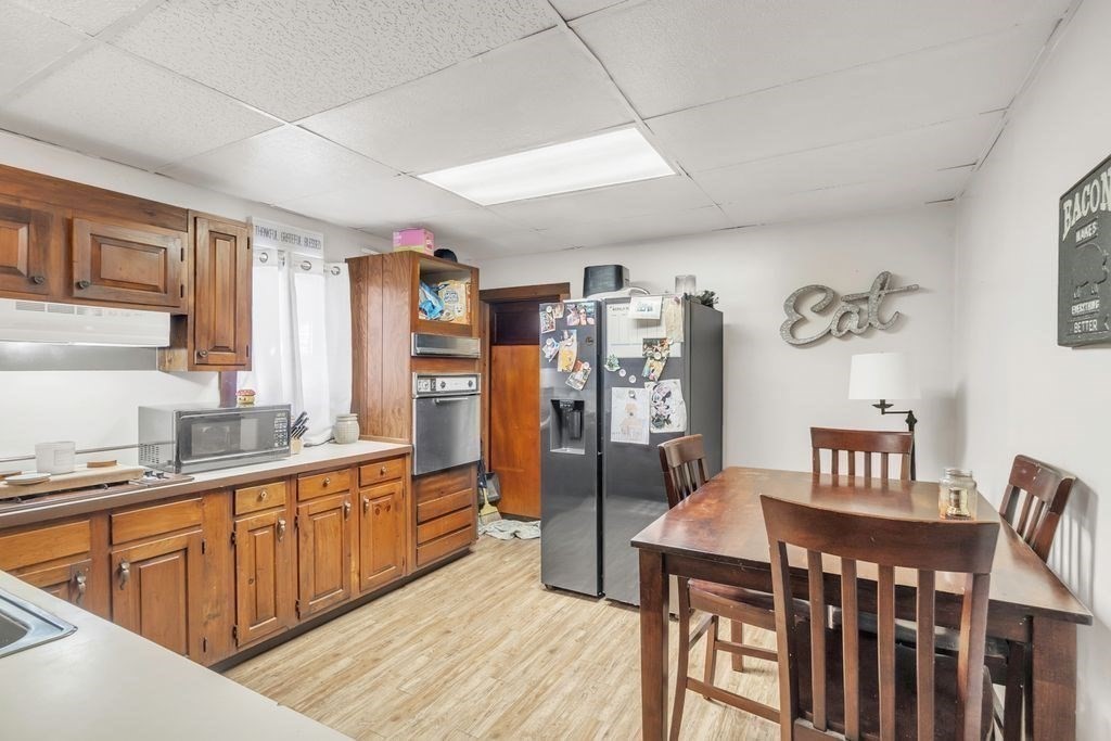 30 Danforth Avenue Pittsfield, MA 01201 - Photo 13 of 25 a kitchen with stainless steel appliances granite countertop a refrigerator a sink dishwasher a dining table and chairs with wooden floor