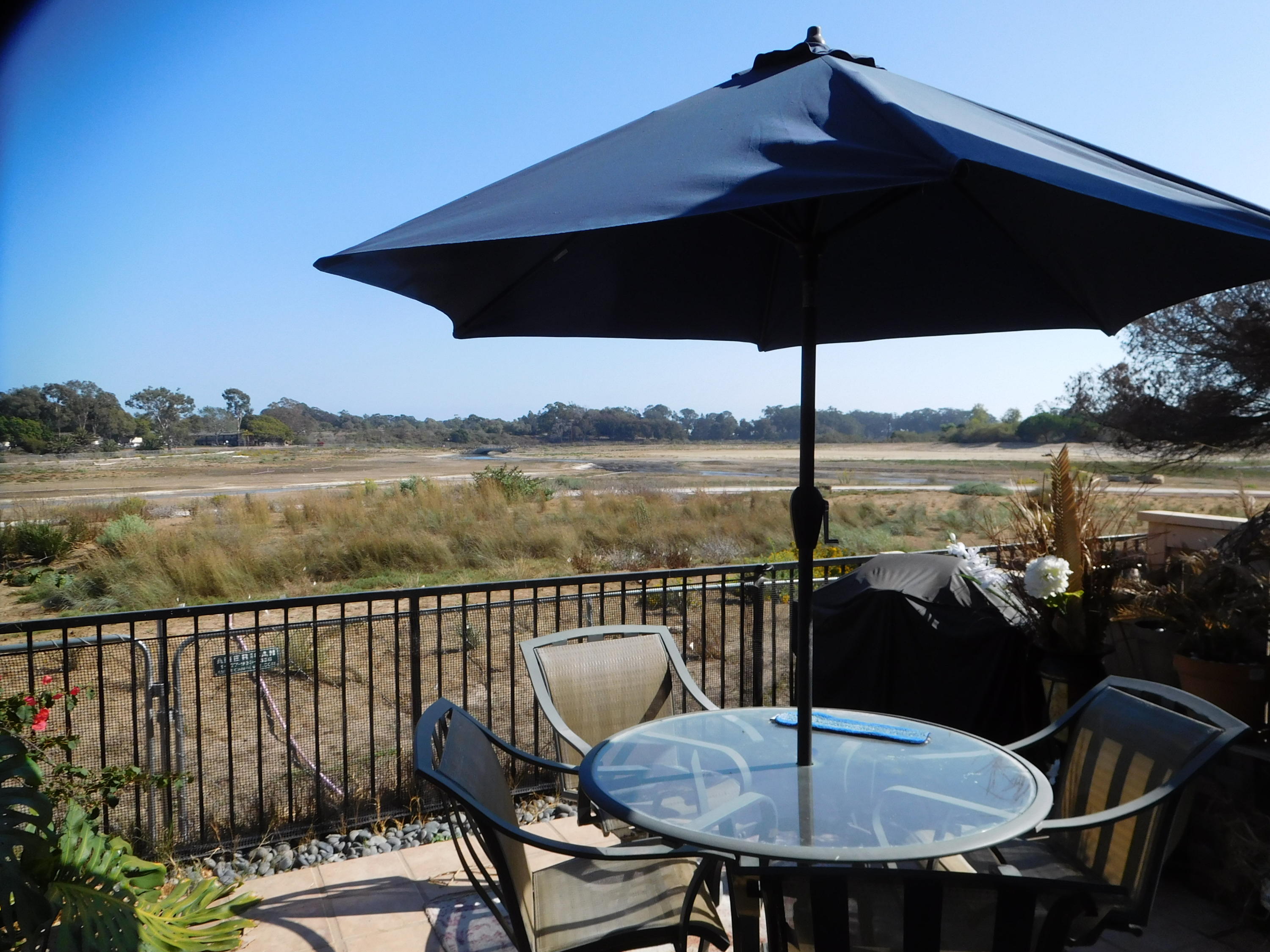 7031 Marymount Way Goleta, CA 93117 - Photo 6 of 9 a roof deck with table and chairs under an umbrella