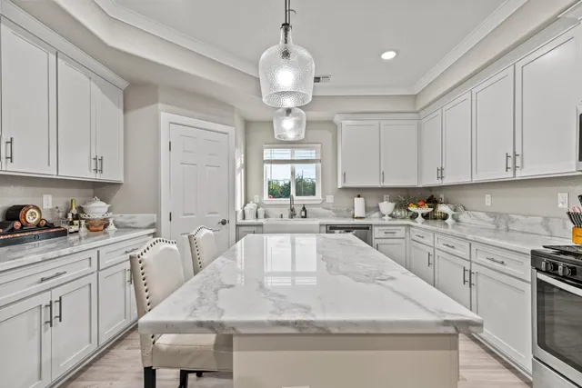 a kitchen with stainless steel appliances granite countertop a sink a stove and microwave with wooden floor