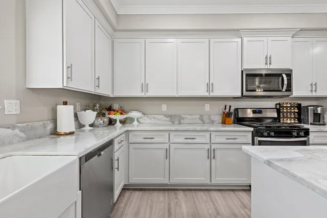 a kitchen with stainless steel appliances granite countertop a sink stove and cabinets