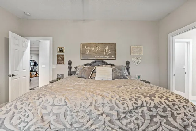 a bedroom with a large bed and a chandelier