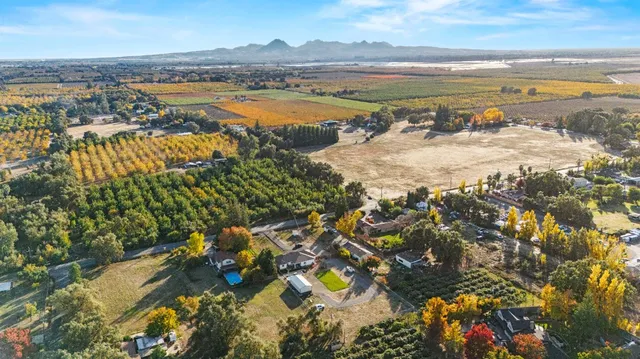 an aerial view of a house with a yard and lake view