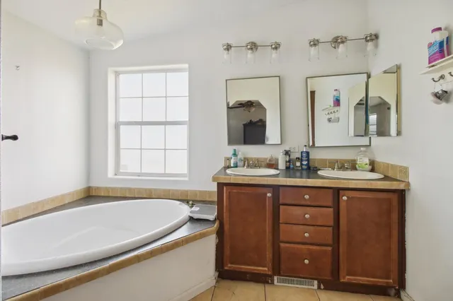 a spacious bathroom with a granite countertop sink and a bathtub