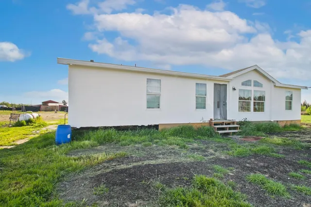 a backyard of a house with table and chairs