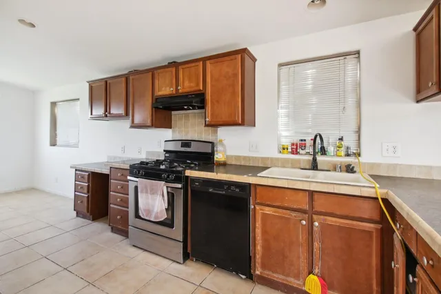 a kitchen with stainless steel appliances granite countertop a sink stove and cabinets