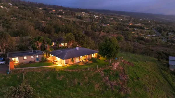 an aerial view of residential houses with outdoor space and trees