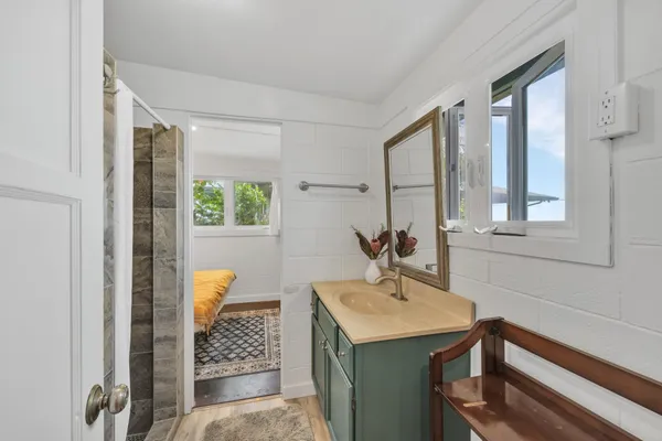 a spacious bathroom with a granite countertop sink and a bathtub