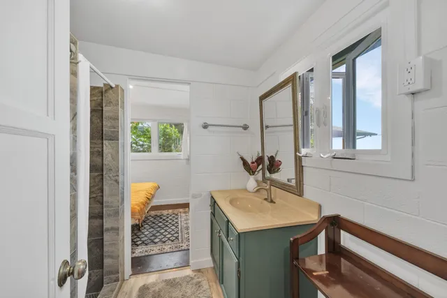 a spacious bathroom with a granite countertop sink and a bathtub