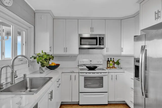 a kitchen with granite countertop a sink stainless steel appliances and cabinets