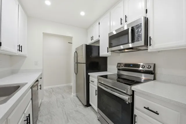 a kitchen with stainless steel appliances a stove microwave and refrigerator