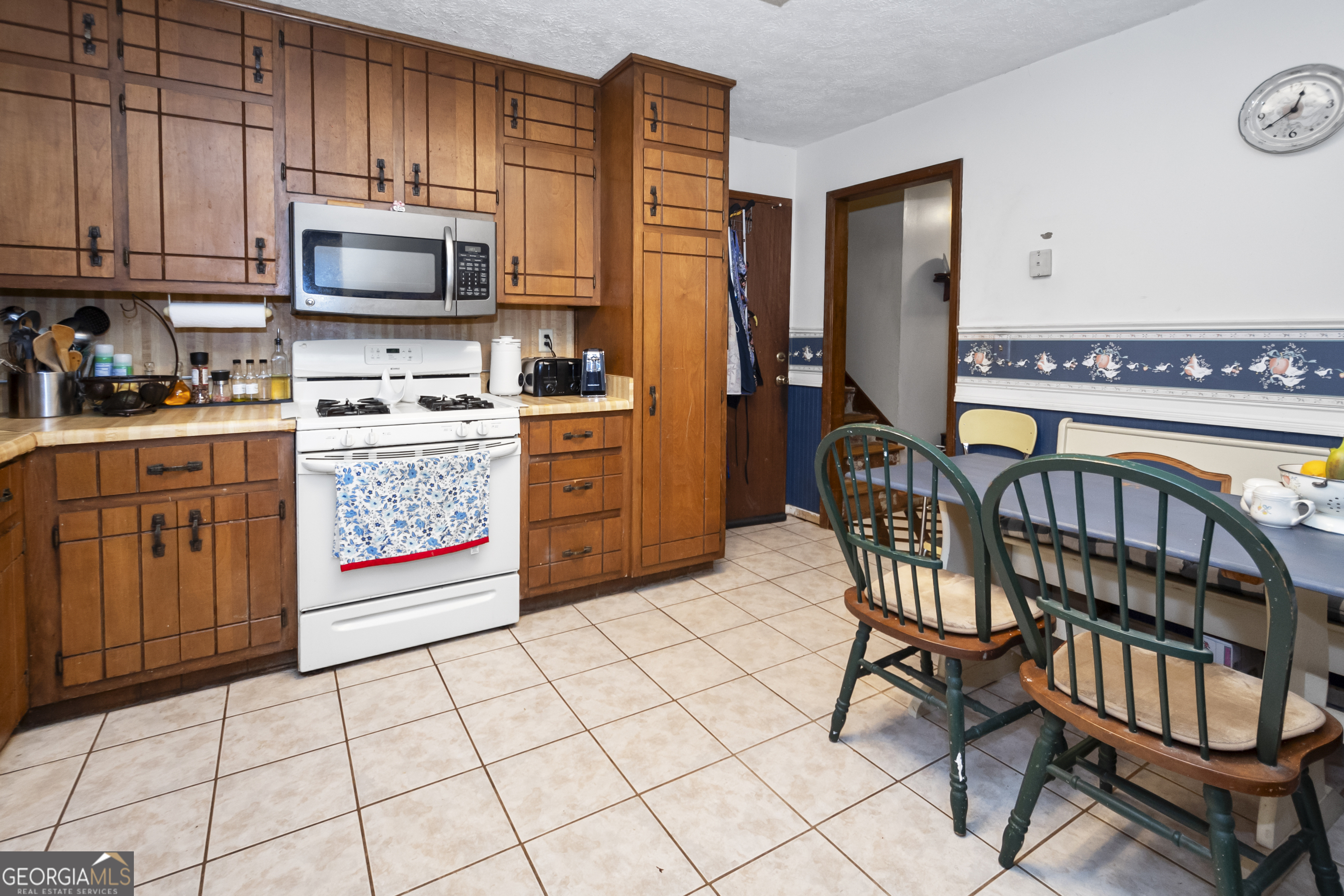 1972 Cox Drive Austell, GA 30168 - Photo 13 of 40 a kitchen with stainless steel appliances a stove a sink cabinets and a dining table