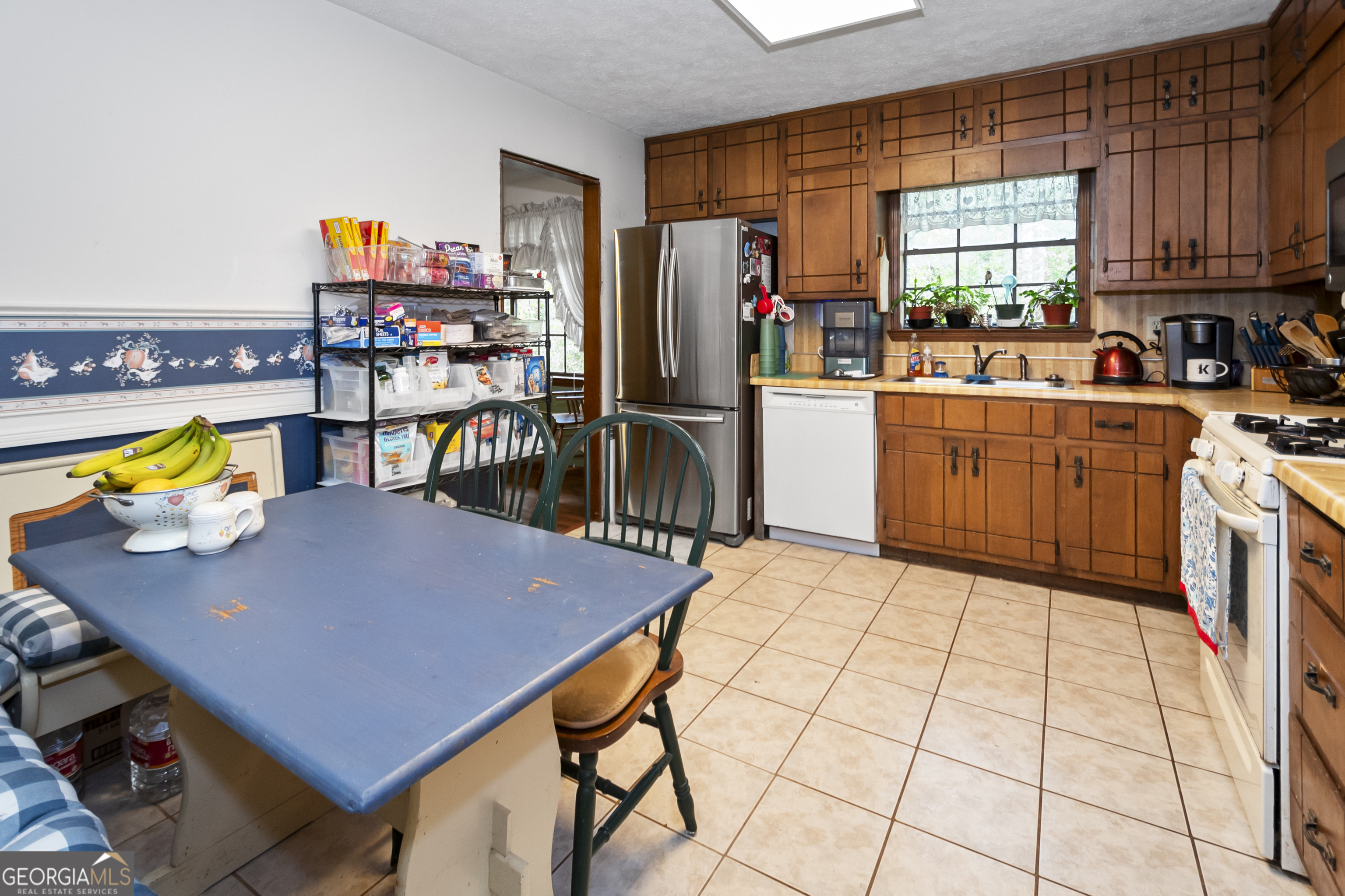 1972 Cox Drive Austell, GA 30168 - Photo 15 of 40 a kitchen with stainless steel appliances a stove a sink cabinets and a dining table