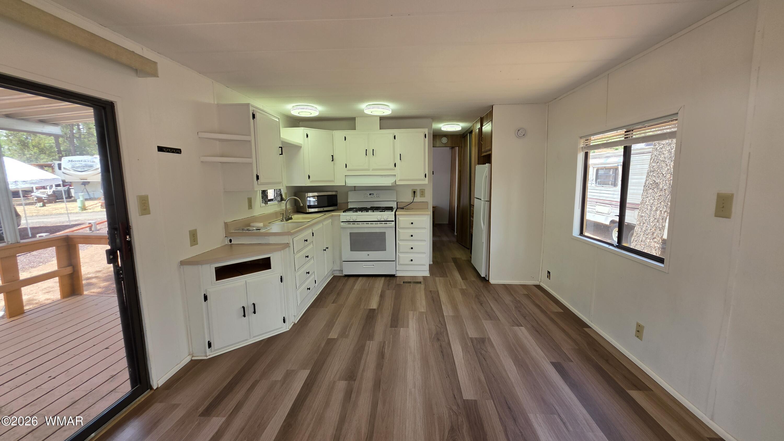 2468 Running Bear Road, Unit 44 Lakeside, AZ 85929 - Photo 6 of 11 a kitchen with white cabinets and wooden floor