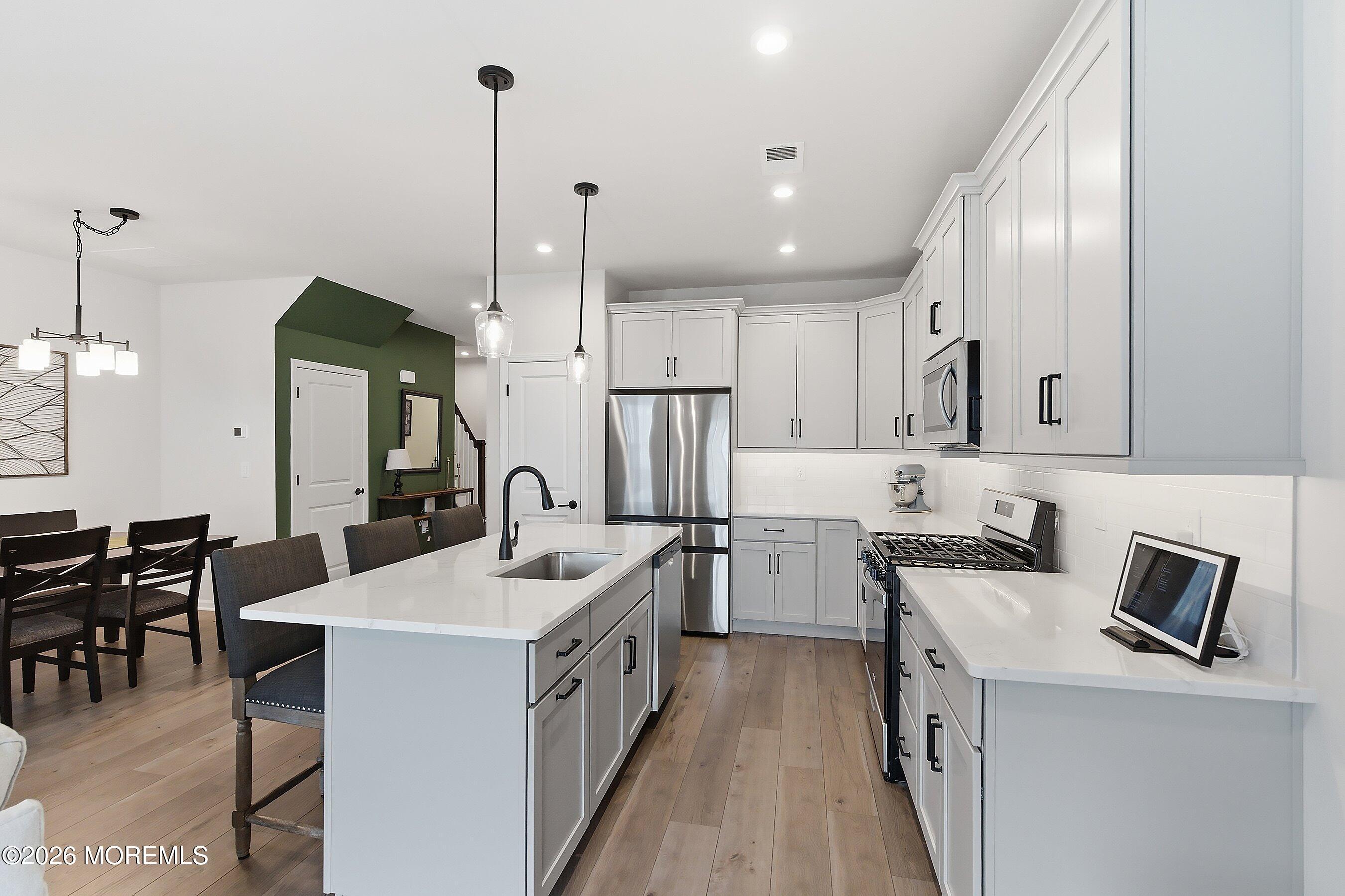 5 Laird Way Neptune, NJ 07753 - Photo 8 of 35 a kitchen with kitchen island granite countertop a sink a counter top space appliances and cabinets