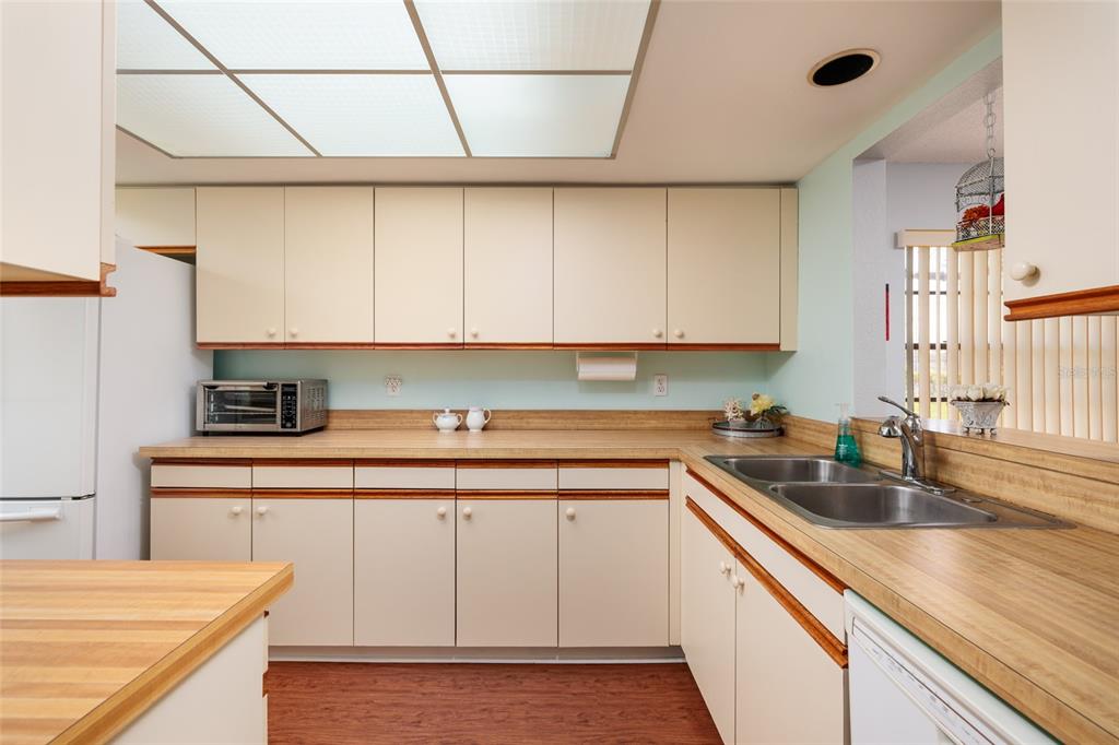 1601 43rd Street, Unit 149 St. Petersburg, FL 33713 - Photo 4 of 51 a kitchen with a sink dishwasher and cabinets with wooden floor