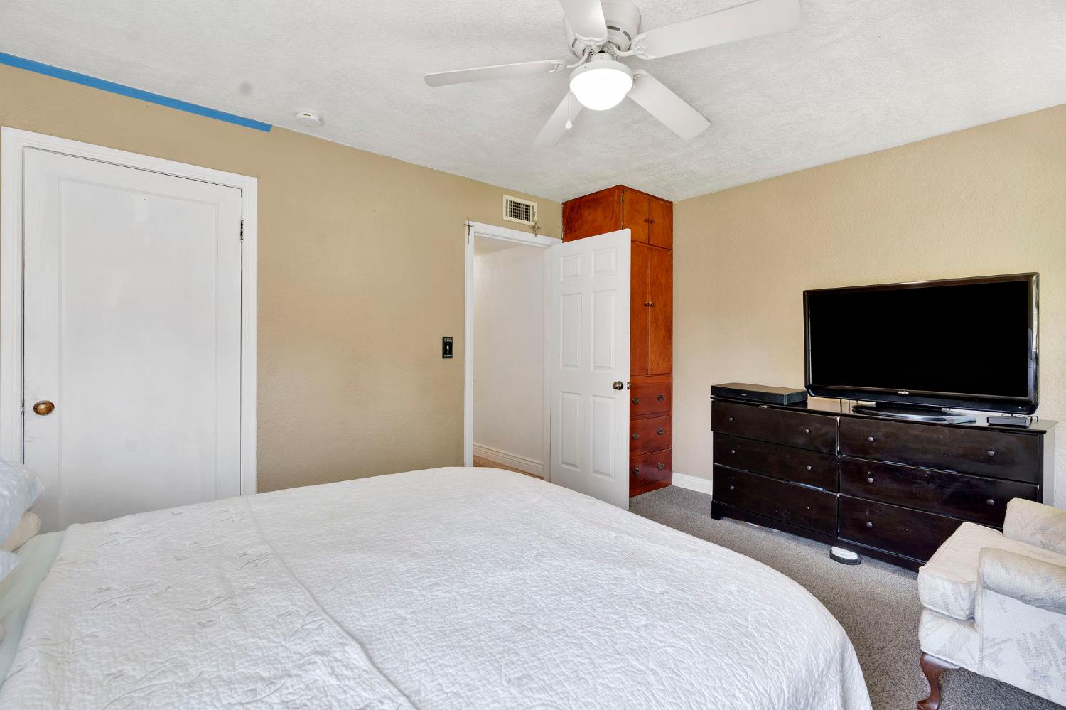 200 Lyons Street Madera, CA 93638 - Photo 19 of 32 a bedroom with a bed and a flat screen tv