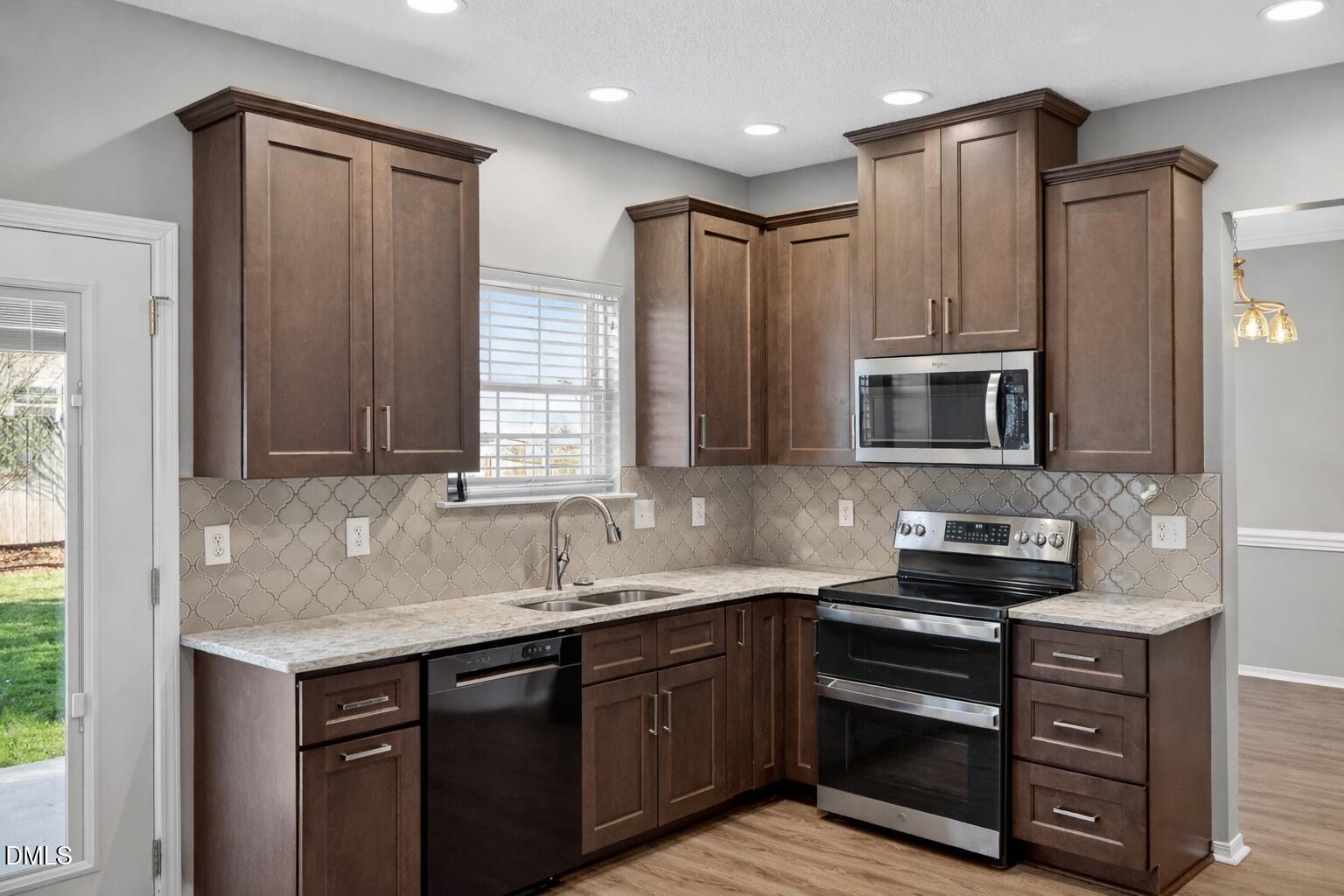 5709 Apalachicula Drive Raleigh, NC 27616 - Photo 10 of 47 a kitchen with stainless steel appliances granite countertop a sink stove and microwave