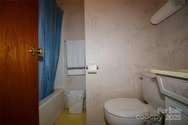 a white toilet sitting next to a shower