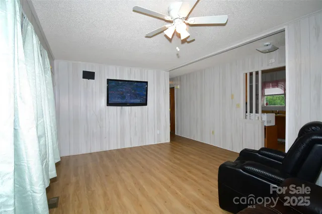 a view of a livingroom with wooden floor and a ceiling fan