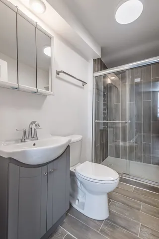 a bathroom with a sink a toilet and shower