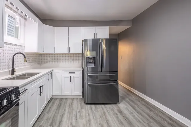 a kitchen with a refrigerator sink and cabinets