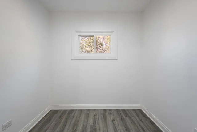 a view of small space with wooden floor and window