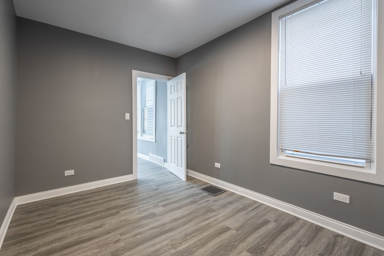 6830 South Honore Street Chicago, IL 60636 - Photo 8 of 31 a view of an empty room with wooden floor and a window
