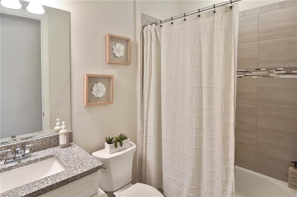 19375 Elston Way Estero, FL 33928 - Photo 15 of 50 a bathroom with a granite countertop sink toilet a mirror and shower