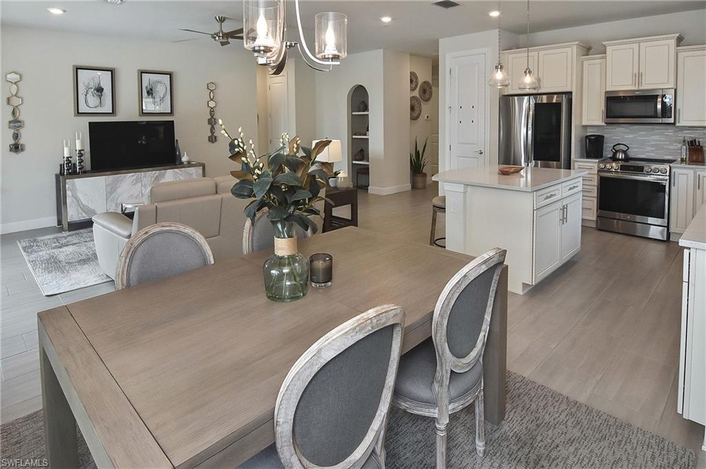 19375 Elston Way Estero, FL 33928 - Photo 27 of 50 a kitchen with stainless steel appliances a dining table and chairs