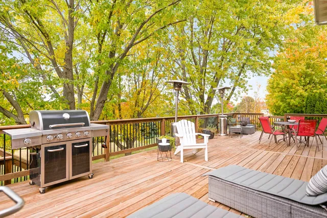 a view of a livingroom with a fireplace a ceiling fan and windows