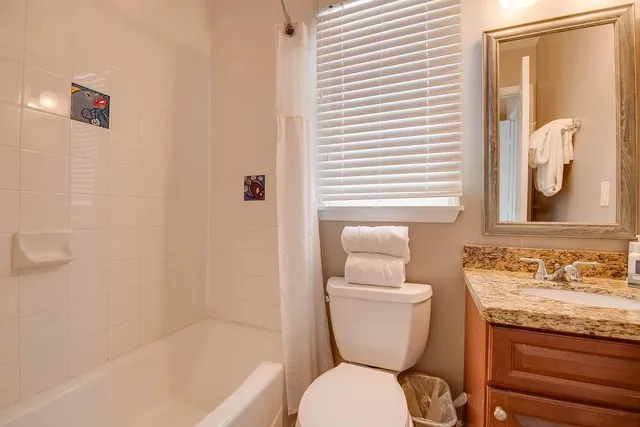 a bathroom with a granite countertop toilet a sink and bathtub