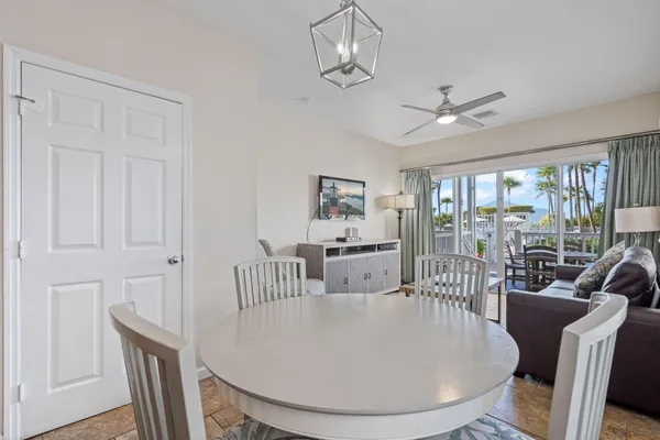 a dining room with furniture a chandelier and wooden floor