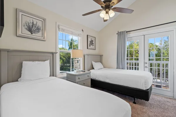 a bedroom with two large bed and a window