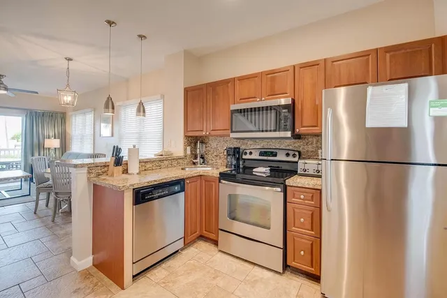 a kitchen with stainless steel appliances granite countertop a refrigerator a stove a sink and a refrigerator