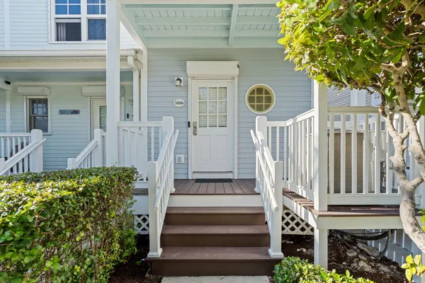 a front view of a house with a tree