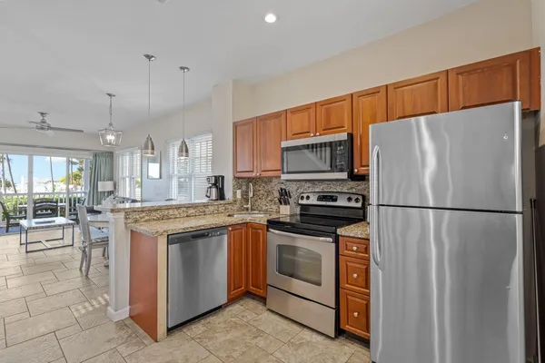 a kitchen with granite countertop a refrigerator stove and sink