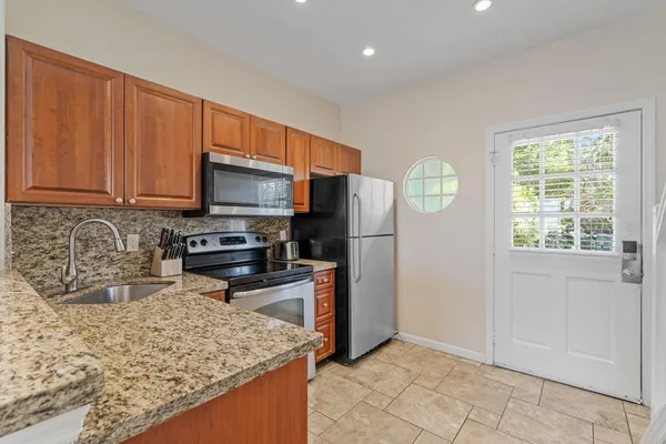 a kitchen with stainless steel appliances granite countertop a refrigerator oven a sink a granite counter space and stainless steel appliances