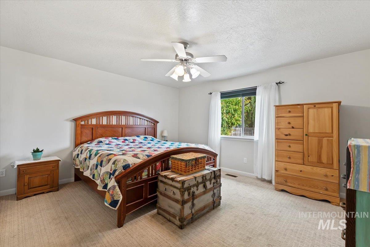 16608 Old Friendship Way Caldwell, ID 83607 - Photo 14 of 32 Bedroom with light colored carpet, a textured ceiling, and ceiling fan