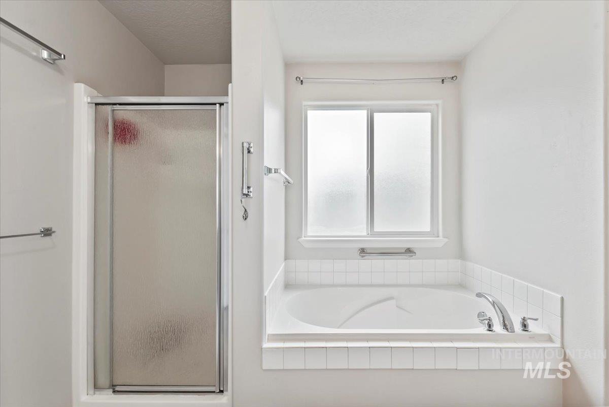 16608 Old Friendship Way Caldwell, ID 83607 - Photo 17 of 32 Full bath featuring a shower stall, a garden tub, and a textured ceiling
