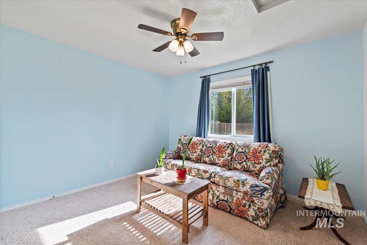 16608 Old Friendship Way Caldwell, ID 83607 - Photo 19 of 32 Living area featuring carpet floors, a textured ceiling, and ceiling fan