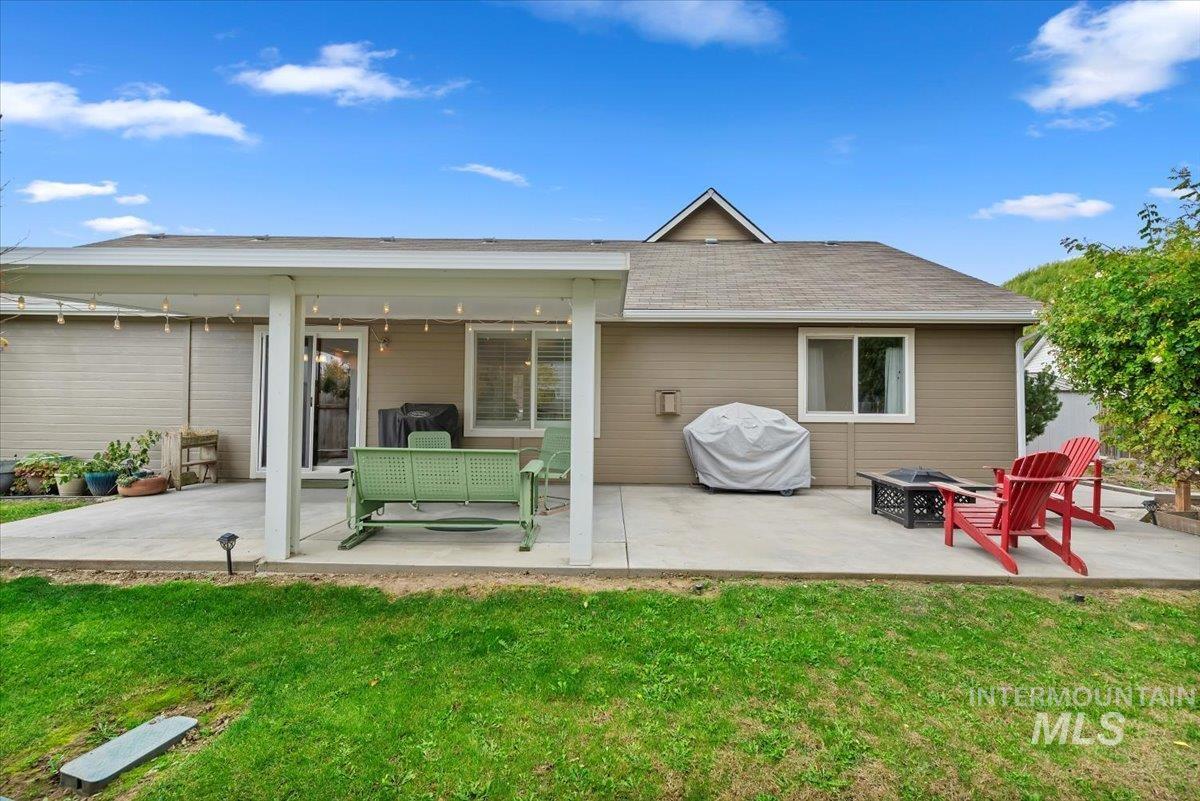 16608 Old Friendship Way Caldwell, ID 83607 - Photo 23 of 32 Rear view of property with a patio area, a yard, an outdoor fire pit, and a shingled roof