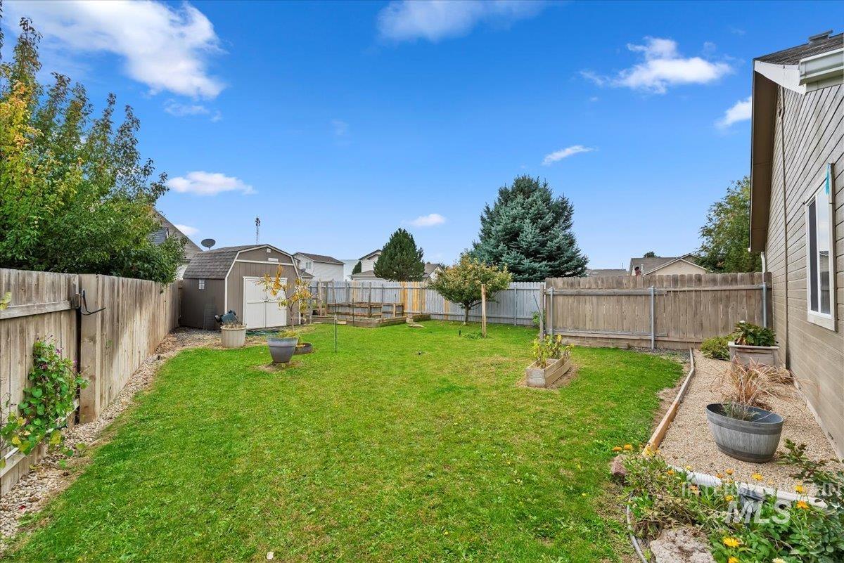 16608 Old Friendship Way Caldwell, ID 83607 - Photo 30 of 32 Fenced backyard with a vegetable garden and a storage shed
