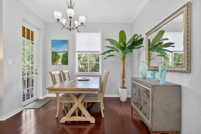 a kitchen with stainless steel appliances granite countertop a stove top oven a sink dishwasher a dining table and chairs with wooden floor