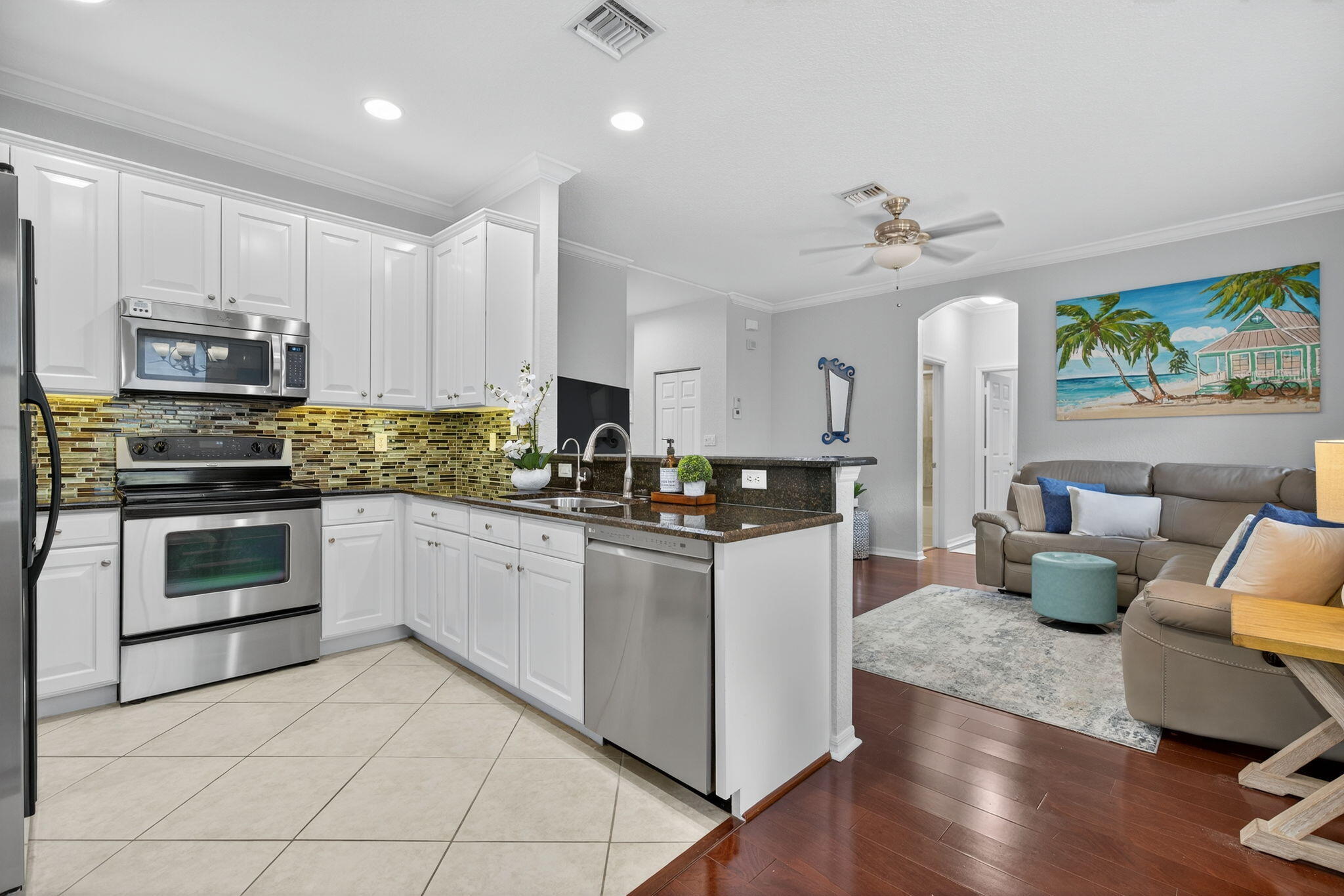 141 Seagrape Drive, Unit 203 Jupiter, FL 33458 - Photo 13 of 39 a kitchen with stainless steel appliances granite countertop a stove top oven a sink dishwasher a dining table and chairs with wooden floor
