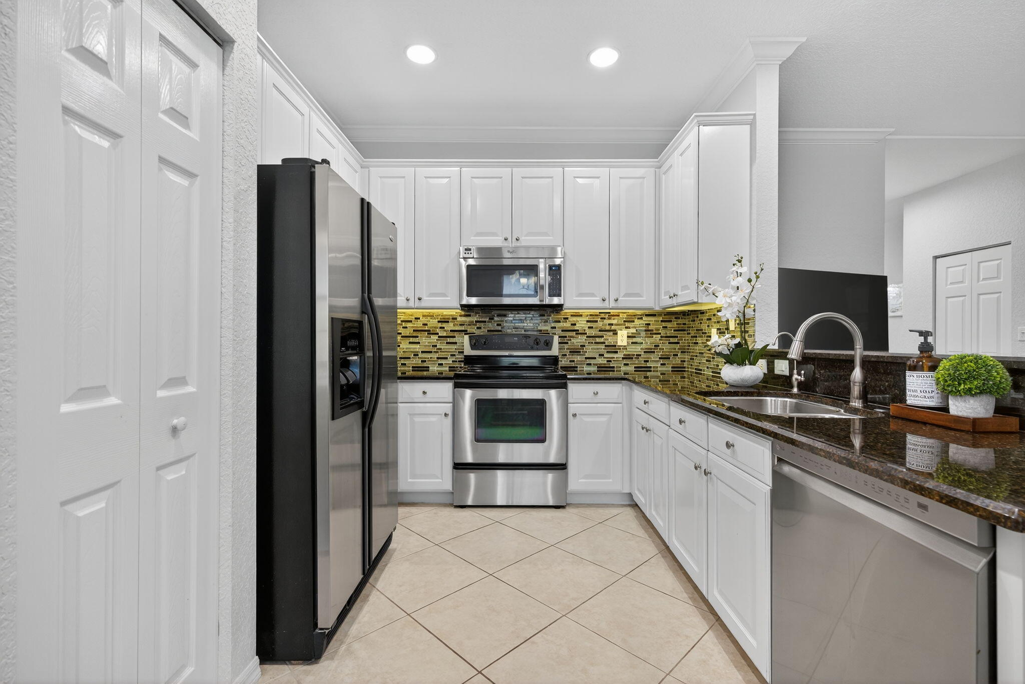 141 Seagrape Drive, Unit 203 Jupiter, FL 33458 - Photo 14 of 39 a kitchen with granite countertop a refrigerator and a sink