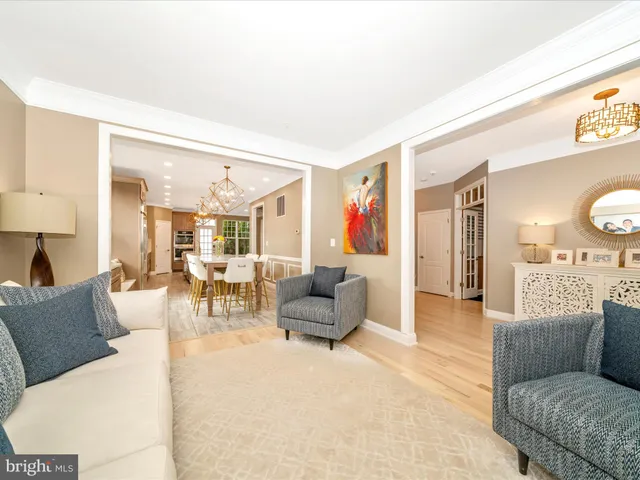 a dining room with wooden floor a chandelier a wooden table and chairs