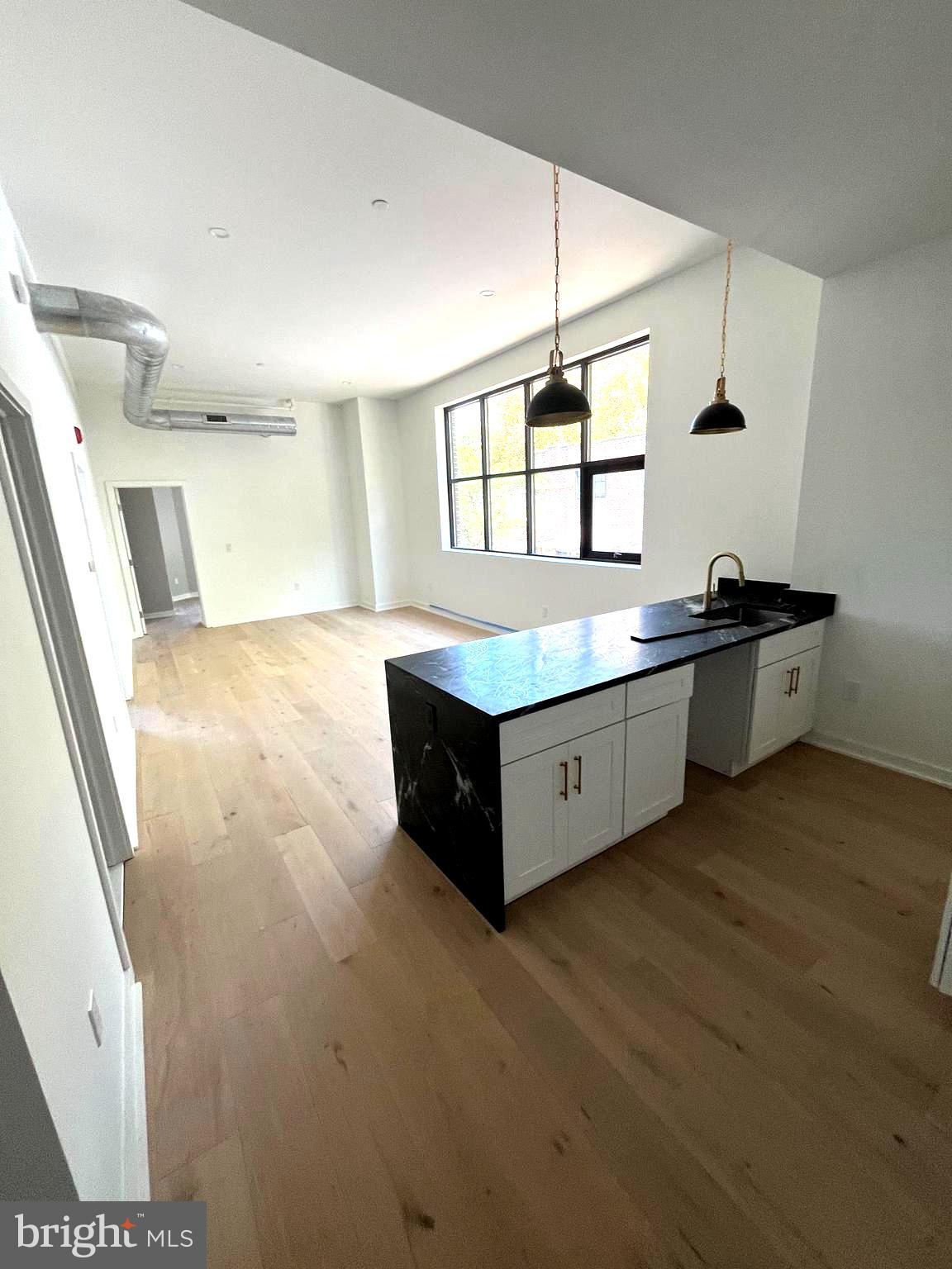 36 North Narberth Avenue, Unit 2C Narberth, PA 19072 - Photo 2 of 7 a spacious bathroom with a granite countertop sink a toilet a mirror and a shower