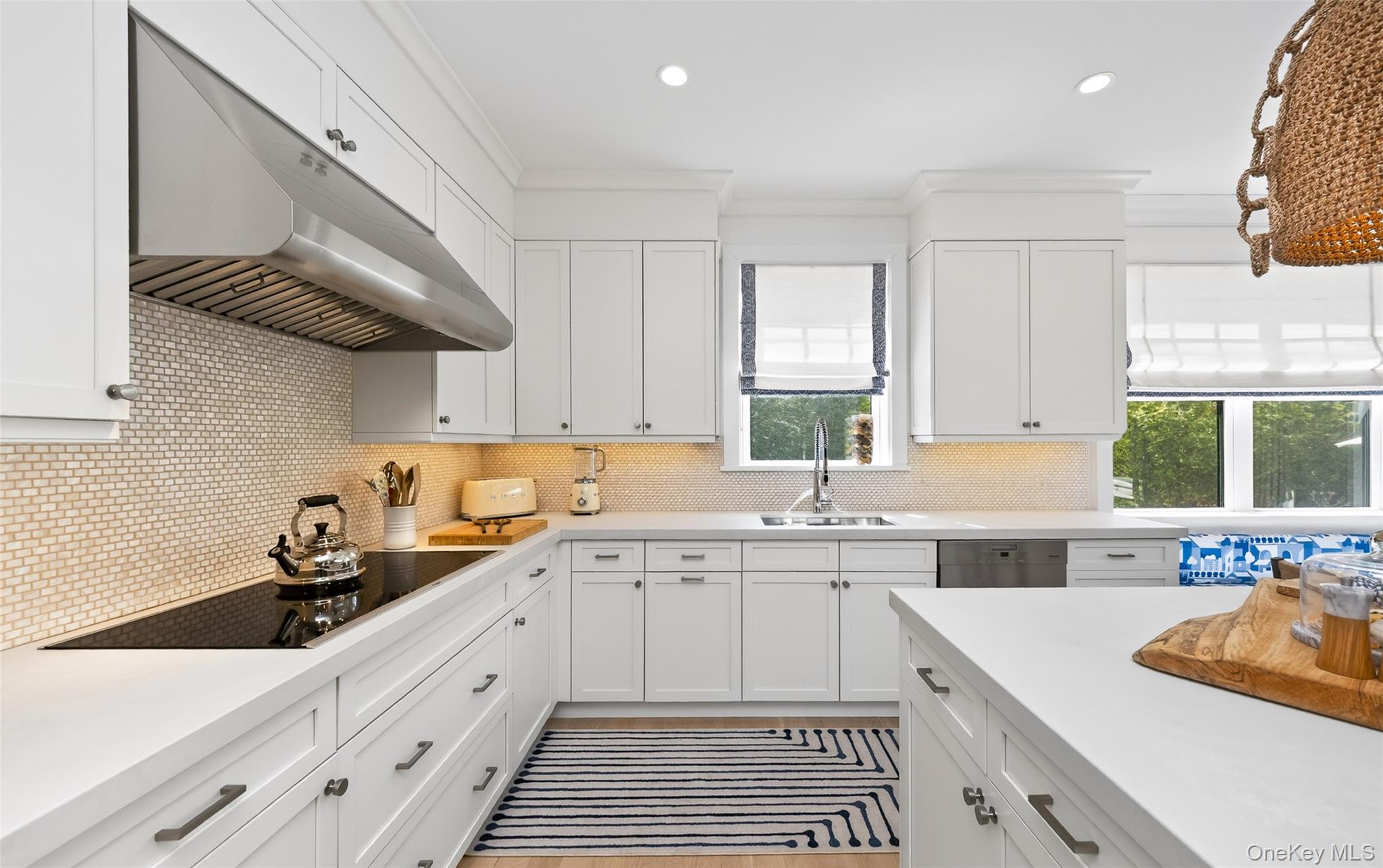 17 Bayview Road Southampton, NY 11968 - Photo 14 of 39 a kitchen with a sink dishwasher a stove and white cabinets with wooden floor