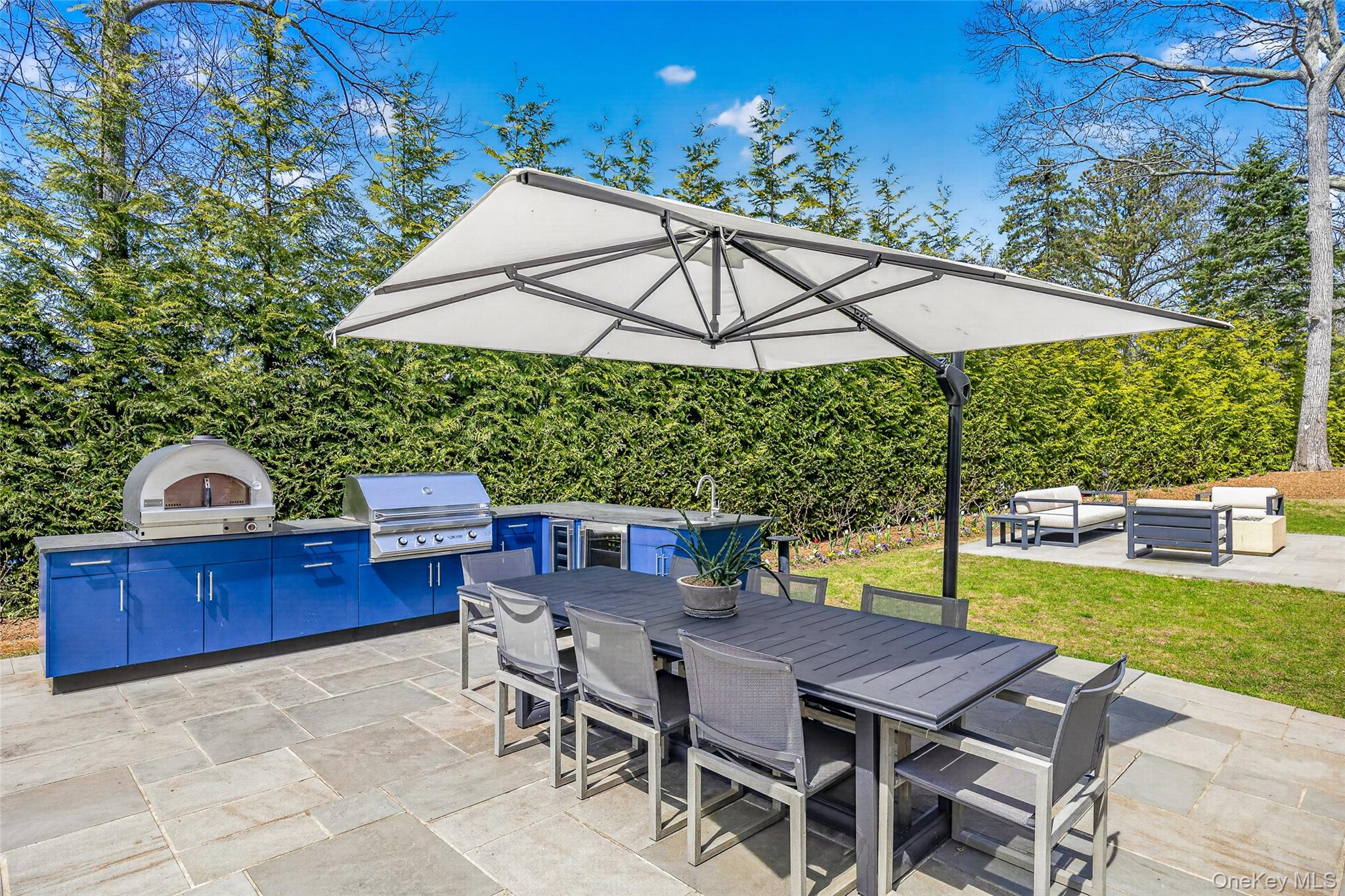17 Bayview Road Southampton, NY 11968 - Photo 17 of 39 a view of a patio with a table and chairs under an umbrella